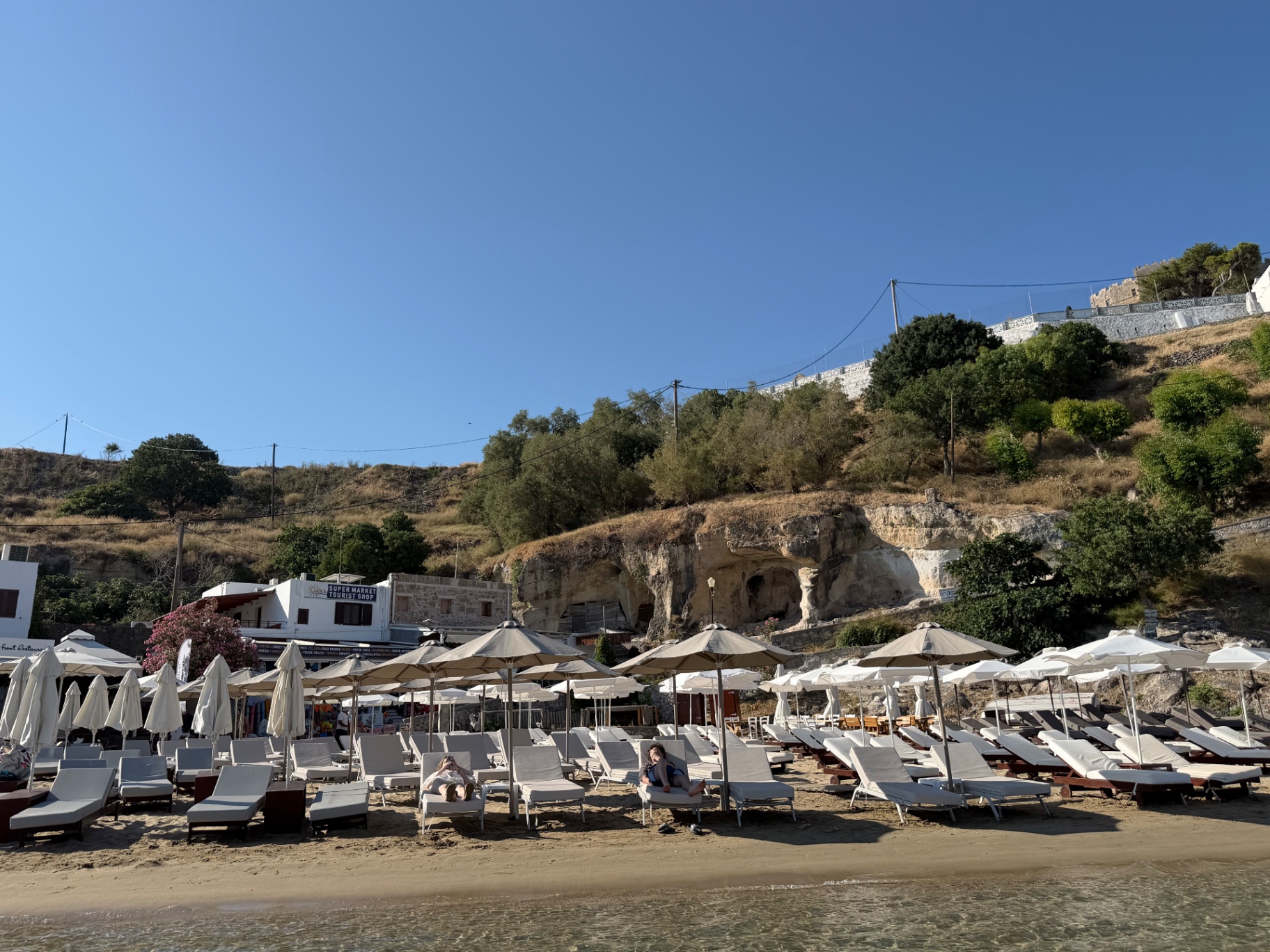 Pallas Beach vanaf het water gezien, met de akropolis van Lindos hoog boven de baai