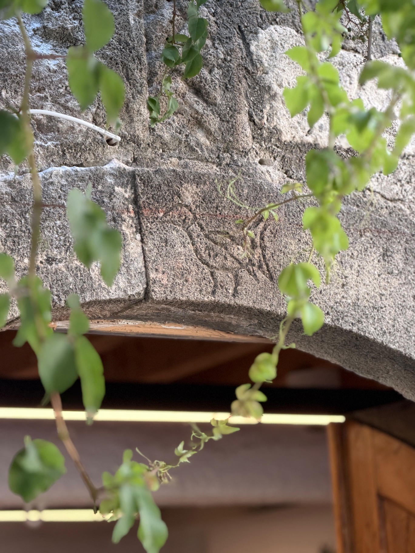 The carved bird on the stone arch above the entrance of Lindos Boathouse